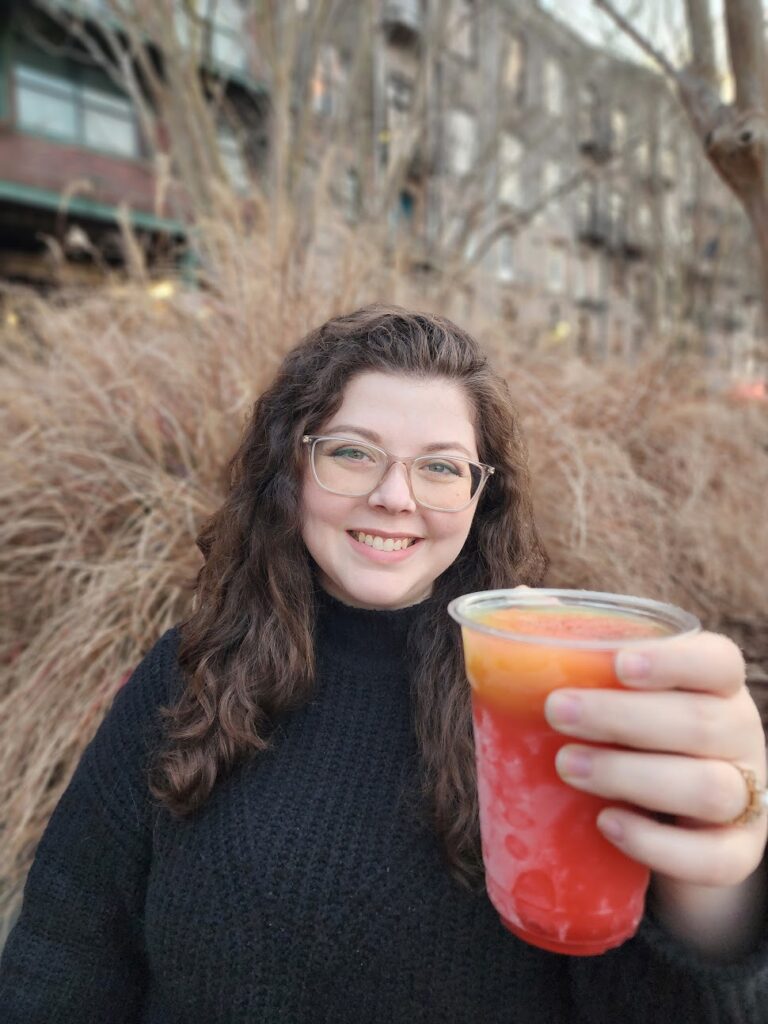 Kathleen holding out a drink for cheers